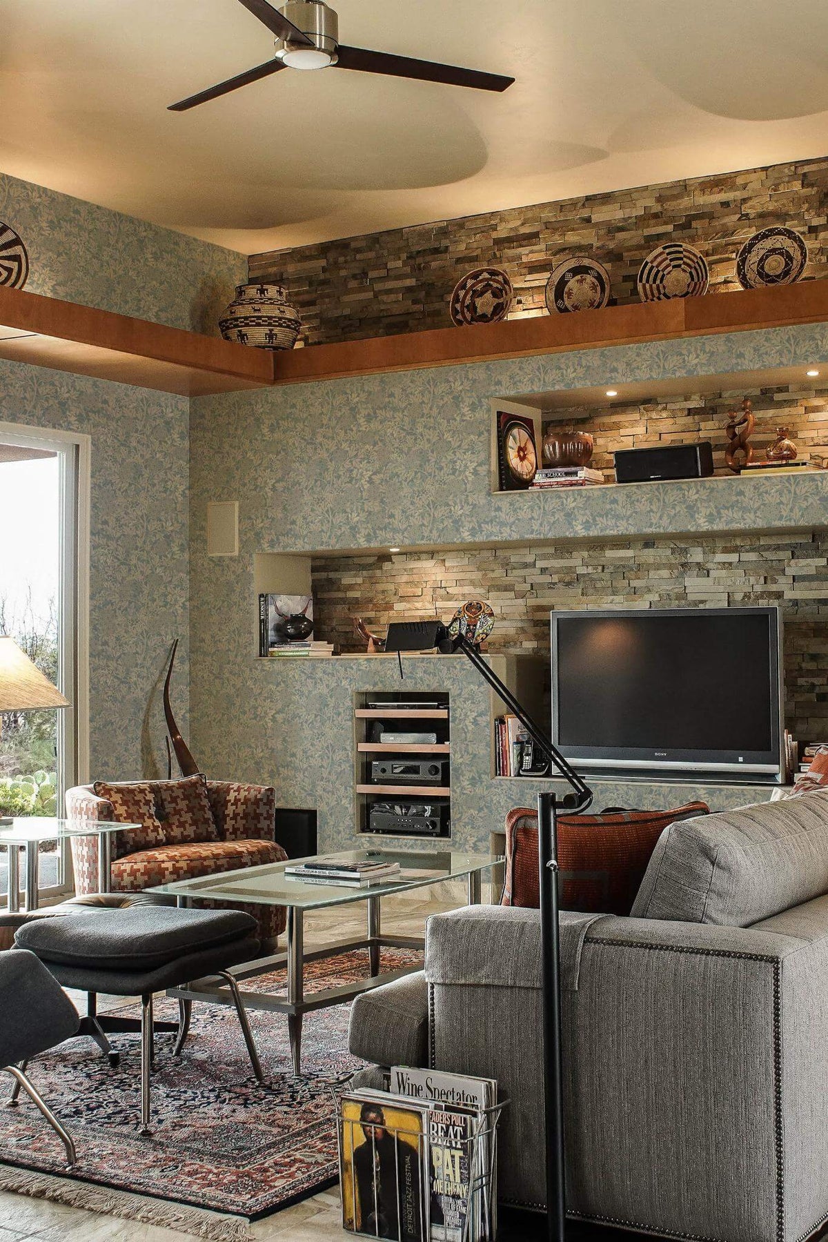 Sala de estar de inspiração mediterrânica com papel de parede de folhagem vintage azul e cinzento